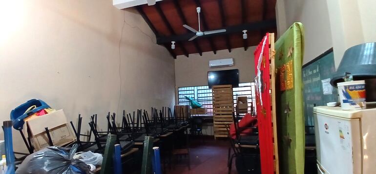 Aula con camino de termitas en la pared, sillas, muebles.