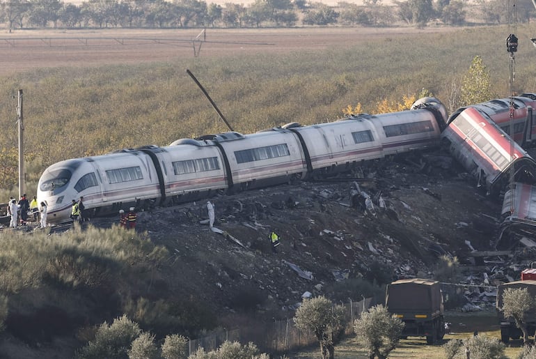 URDA (TOLEDO), 29/10/2026.- Personas que investigan el suceso junto a camiones del ejército y grúas pesadas trabajan este jueves en los convoyes de los trenes de Renfe e Iryo que colisionaron ayer en Urda (Toledo). EFE/ J.J.Guillen
