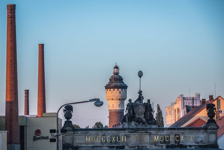 Pilsen, República Checa. Vista de la puerta, chimeneas y torre de agua de la fábrica de cerveza Pilsner Urquell.