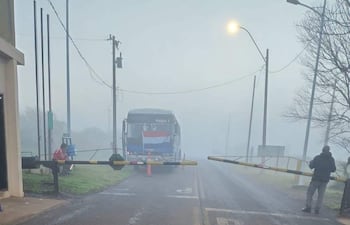 Ambiente nublado en la ruta D022 con autobús y una persona al costado atendiendo el acceso, todo bajo densa niebla.