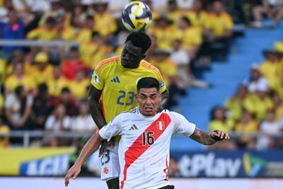 El colombiano Davinson Sánchez se eleva para rechazar el balón ante el peruano Luis Ramos.