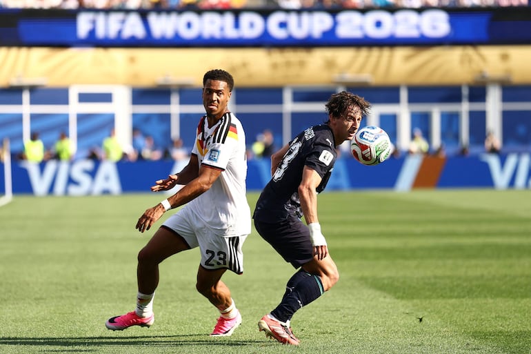 El defensa de Alemania Felix Nmecha (I) y el centrocampista de Paraguay #23 Matías Galarza (D) luchan por el balón durante el partido de fútbol de los dieciseisavos de final de la Copa del Mundo 2026 entre Alemania y Paraguay en el Boston Stadium en Foxborough.