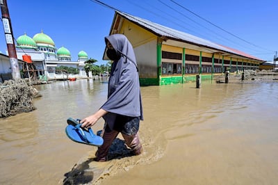 Una mujer camina en una zona inundada de la localidad de Meureudu, en la provincia de Aceh, Indonesia.