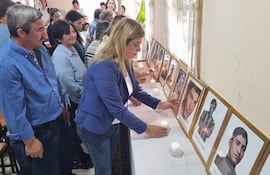 Judith Rolón realiza el encendido simbólico de una vela frente al retrato de su padre, Martín Rolón, como símbolo de recordación durante el acto en Santa Rosa, Misiones.