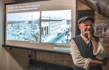 Dietmar Arnold, presidente de la asociación “Berliner Unterwelten” (Subterráneos de Berlín), posa junto a fotografías de archivo que muestran el búnker subterráneo (izq.) de la Nueva Cancillería del Reich durante su construcción, a finales de la década de 1930, en el distrito de Mitte, durante una conferencia de prensa en Berlín, el 11 de agosto de 2026.