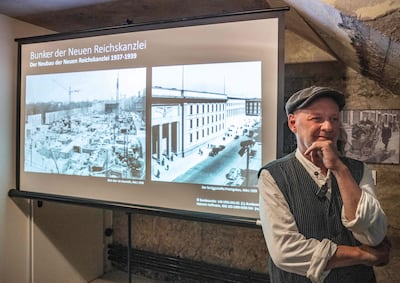 Dietmar Arnold, presidente de la asociación “Berliner Unterwelten” (Subterráneos de Berlín), posa junto a fotografías de archivo que muestran el búnker subterráneo (izq.) de la Nueva Cancillería del Reich durante su construcción, a finales de la década de 1930, en el distrito de Mitte, durante una conferencia de prensa en Berlín, el 11 de agosto de 2026.