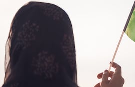 Mujer musulmana bandera de Arabia Saudita al atardecer.