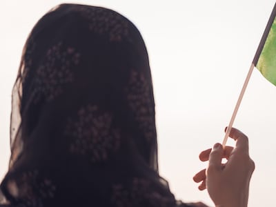 Mujer musulmana bandera de Arabia Saudita al atardecer.
