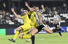 Momento exacto en el que el delantero Lorenzo Melgarejo se apresta a rematar al arco ante la oposición del defensor Lucas Monzón, que no llegó a interceptar el balón que tuvo destino de red.