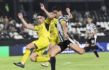 Momento exacto en el que el delantero Lorenzo Melgarejo se apresta a rematar al arco ante la oposición del defensor Lucas Monzón, que no llegó a interceptar el balón que tuvo destino de red.