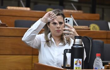 Kattya González baja el pulgar en una transmisión online con su teléfono celular.