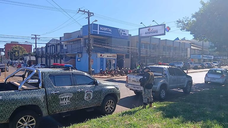 Agente de policía de pie conversando junto a camionetas de Fuerzas Especiales GEO y Policía en ambiente urbano diurno.