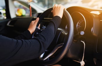 Manos sobre el volante de un auto.