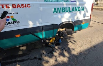 Ambulancia con una rueda levantada y herramientas en el suelo; no hay personas visibles en la escena.