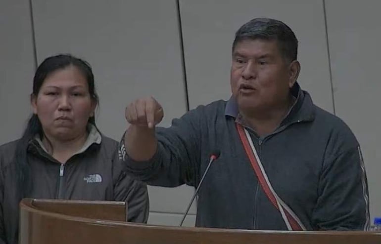 Isabelino Bogado, de cabello corto y canoso, habla enfáticamente en chaqueta gris; Delfina Armoa escucha atentamente, vistiendo chaqueta oscura en recinto oficial.