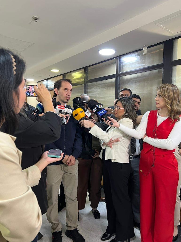 Hombre de chaqueta negra habla en el Congreso, rodeado de otros periodistas grabando con teléfonos móviles.