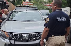 Un agente policial de Control de Automotores se dispone a verificar la camioneta Mistubishi L 200 Tritón Sabana blanca, que fue localizada en Ciudad del Este, poco después de ser robada en Foz de Yguazú (Brasil).