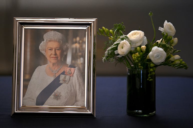 Vista de un retrato de la difunta reina Isabel II y un libro de condolencias para visitantes, en la casa del embajador británico en Buenos Aires, Argentina, el 9 de septiembre de 2022.