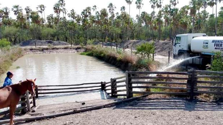 El camión cisterna recarga el tajamar de un pequeño productor de la zona.