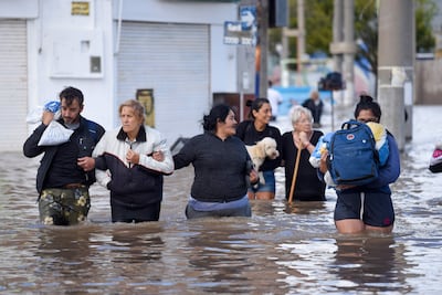 La gente camina por las aguas inundadas el día después de una fuerte tormenta en Bahía Blanca, 600 km al sur de Buenos Aires, el 8 de marzo de 2025. Al menos diez personas murieron y más de 1.000 fueron evacuadas en la ciudad portuaria argentina de Bahía Blanca cuando las lluvias torrenciales inundaron casas y hospitales, destruyeron carreteras y obligaron a las autoridades a cortar la electricidad.