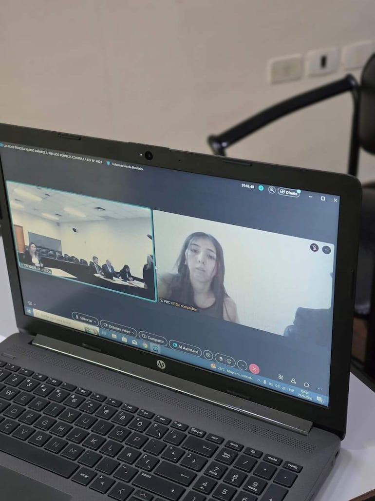 Lourdes Teresita Ramos Ramírez en video llamada, con expresión seria, rodeada de un entorno de oficina junto a múltiples asistentes.