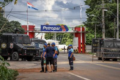 Camiones antidisturbios permanecen frente a una protesta de sectores camioneros que exigen un "libre mercado" y "sana competencia" frente a la sede de Petróleos Paraguay (PETROPAR) hoy, en Villa Elisa (Paraguay). Los camioneros en Paraguay se movilizan para presionar al Parlamento en momentos en se debate en sesión extraordinaria un proyecto de ley para crear un fondo de estabilización del precio de los combustibles. EFE/ Nathalia Aguilar