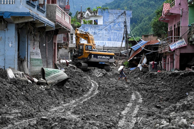 Un hombre camina entre el lodo tras las inundaciones repentinas ocurridas en Devighat, en el distrito nepalí de Nuwakot. Este lunes Nepal entierra algunos de los cientos de cuerpos recuperados después de que una inundación devastadora, similar a un tsunami, arrasara la región del Himalaya, llevándose consigo aldeas enteras y dejando a miles de personas aún desaparecidas. Familias desconsoladas han abarrotado los centros de rescate y los hospitales en busca de sus seres queridos, mientras otras afrontan la sombría tarea de identificar cadáveres en morgues saturadas. 