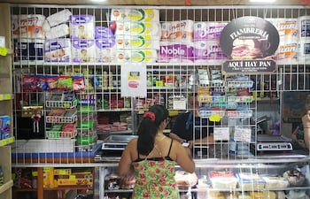 Mujer realiza compras en el almacén de su barrio.
