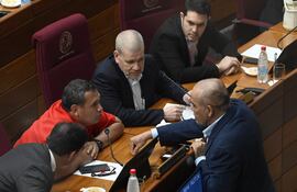 El senador Derlis Maidana conversa con el presidente del Senado, Basilio "Bachi" Nuñez y otros senadores en la sala de sesiones del Senado