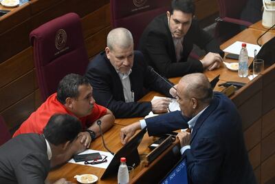 El senador Derlis Maidana conversa con el presidente del Senado, Basilio "Bachi" Nuñez y otros senadores en la sala de sesiones del Senado