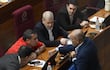El senador Derlis Maidana, con camisa roja, conversa con el presidente del Senado, Basilio "Bachi" Nuñez y otros senadores en la sala de sesiones del Senado.