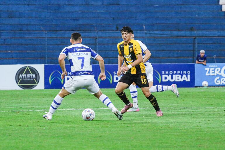 El extremo de Guaraní, Derlis Rodríguez encara la marca del delantero, Elías Alfonso, del Sportivo 2 de Mayo.