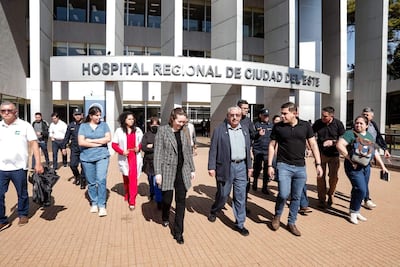 Isaías Fretes conversa con mujer de cabello oscuro, rodeado de personas en el exterior del hospital, todos con expresiones de alegría.