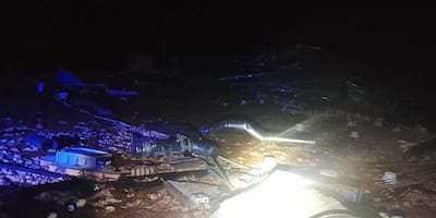Escombros de un gallinero en un entorno oscuro tras un fuerte temporal, sin personas visibles en la escena.