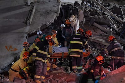 Integrantes de organismos de rescate sacan un cuerpo sin vida de los escombros de un edificio que se derrumbó en Sao Paulo (Brasil).