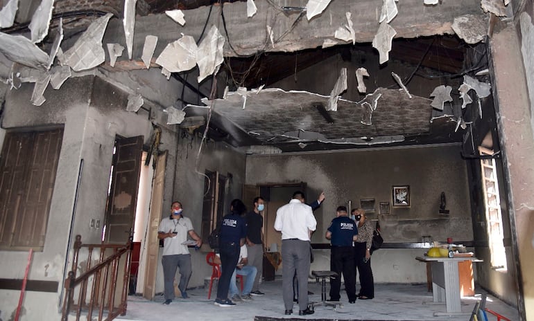 Los fiscales Lorenzo Lezcano y María González, junto a policías, verifican los daños en la sede de la ANR.