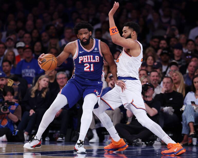 Joel Embiid de Philadelphia 76ers se enfrenta a la marca del dominicano Karl-Anthony Towns de New York Knicks durante el Juego 1 de las Semifinales del Este en los Playoff de la NBA.