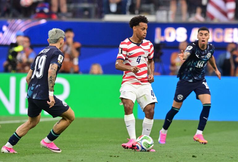 El mediocampista de Paraguay Julio Enciso y el mediocampista de Estados Unidos Tyler Adams luchan por el balón durante el partido de fútbol del Grupo D de la Copa Mundial 2026 entre Estados Unidos y Paraguay en el Los Angeles Stadium en Inglewood