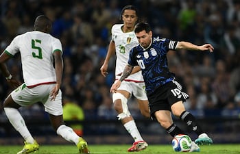 La estrella de Argentina, Lionel Messi, lucha por el balón con el defensor de Mauritania, Lamine Ba, y el mediocampista Oumar Ngom, durante un partido de fútbol amistoso entre Argentina y Mauritania en el estadio La Bombonera en Buenos Aires.