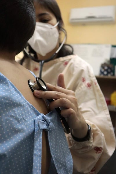 Una doctora verifica los pulmones de un niños con Fibrosis Quística.