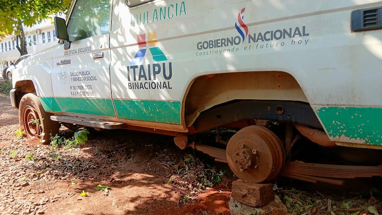 Ambulancia blanca con detalles verdes, inactiva sobre terreno de tierra, con logotipo de Itaipú Binacional.