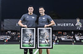 Óscar Cardozo y Roque Santa Cruz, jugadores de Libertad, posan para una fotografía con el homenaje realizado por el club en la previa de un partido de la Primera División de Paraguay en el estadio La Huerta, en Asunción, Paraguay.