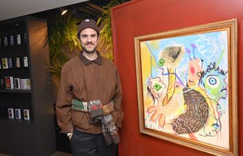 Cacho Falcón posa junto a una de las pinturas que exhibió en el local de Alemania Cell.