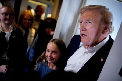 El presidente de Estados Unidos, Donald Trump, acompañado de su nieta Chloe (centro), habla con los medios de comunicación a bordo del Air Force One el 29 de julio de 2025 durante un vuelo.