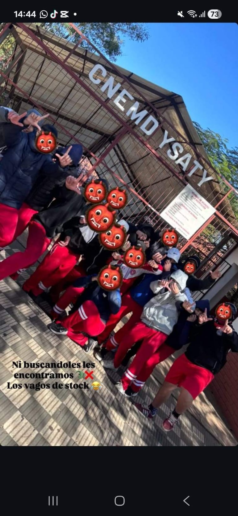 Grupo de padres del Colegio Ysaty vestido de rojo con expresiones preocupadas en manifestación al aire libre.