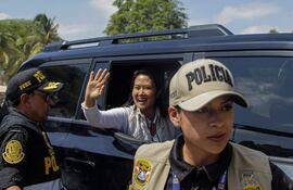 La presidenta de Perú, Keiko Fujimori, saluda desde el interior de una camioneta.