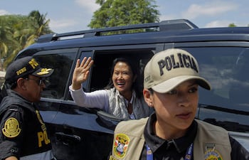 La presidenta de Perú, Keiko Fujimori, saluda desde el interior de una camioneta.