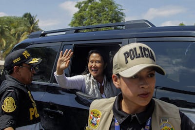 La presidenta de Perú, Keiko Fujimori, saluda desde el interior de una camioneta.