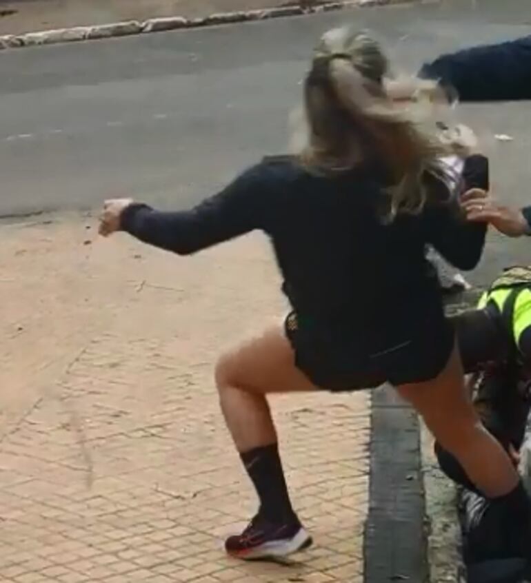 Momento en que otro inspector empuja a la señora Agustina, quien cae de espaldas en la vereda