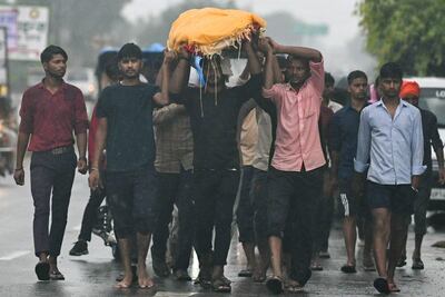 Varias personas llevan el cuerpo de uno de los fallecidos en la estampida, durante una procesión fúnebre este miércoles.